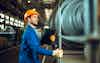 Worker with notebook large turbine on background